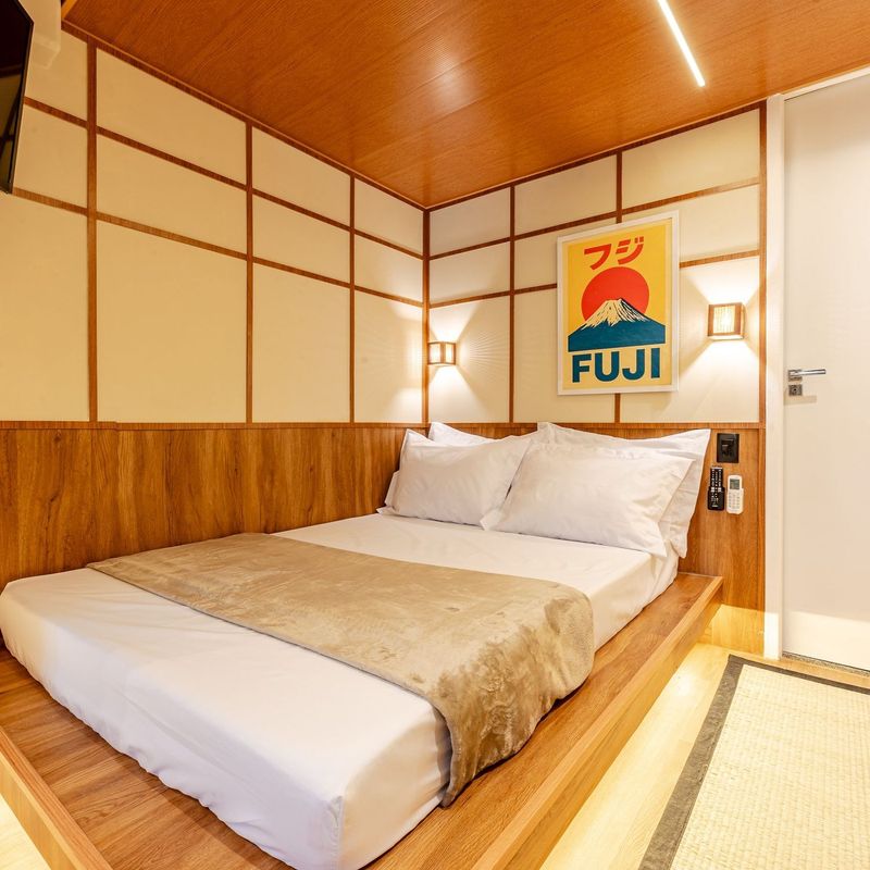 Quarto Fuji do TŌKA, com cama baixa sobre tablado de madeira e o quadro do Monte Fuji na parede